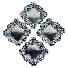 Set di quattro piatti per noci e caramelle placcati in argento Repoussage - America, 1940 ca.