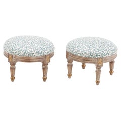 A pair of petite French Louis XVI style upholstered foot stools.