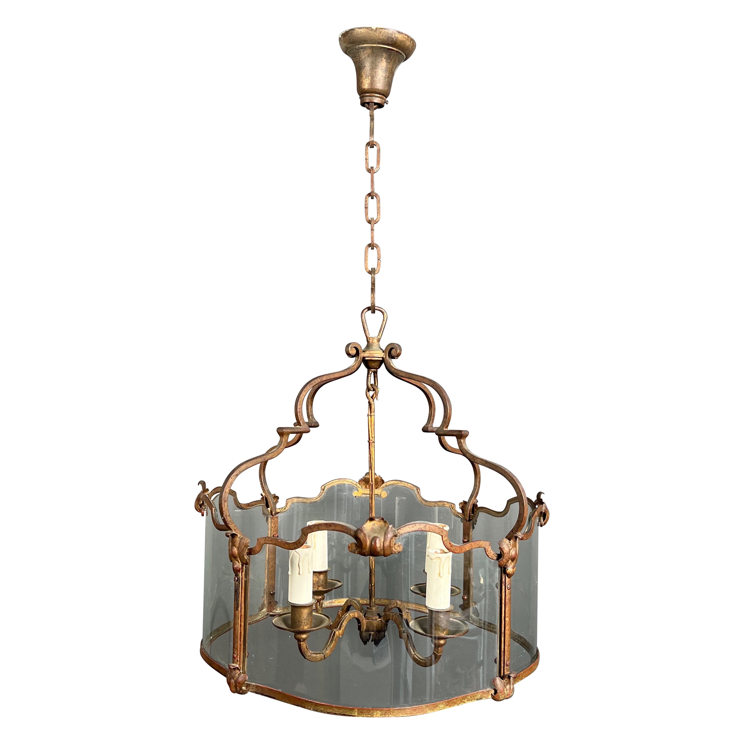 Rare lanterne à 4 lumières en fer forgé battu doré avec verres incurvés. Travail français. en vente