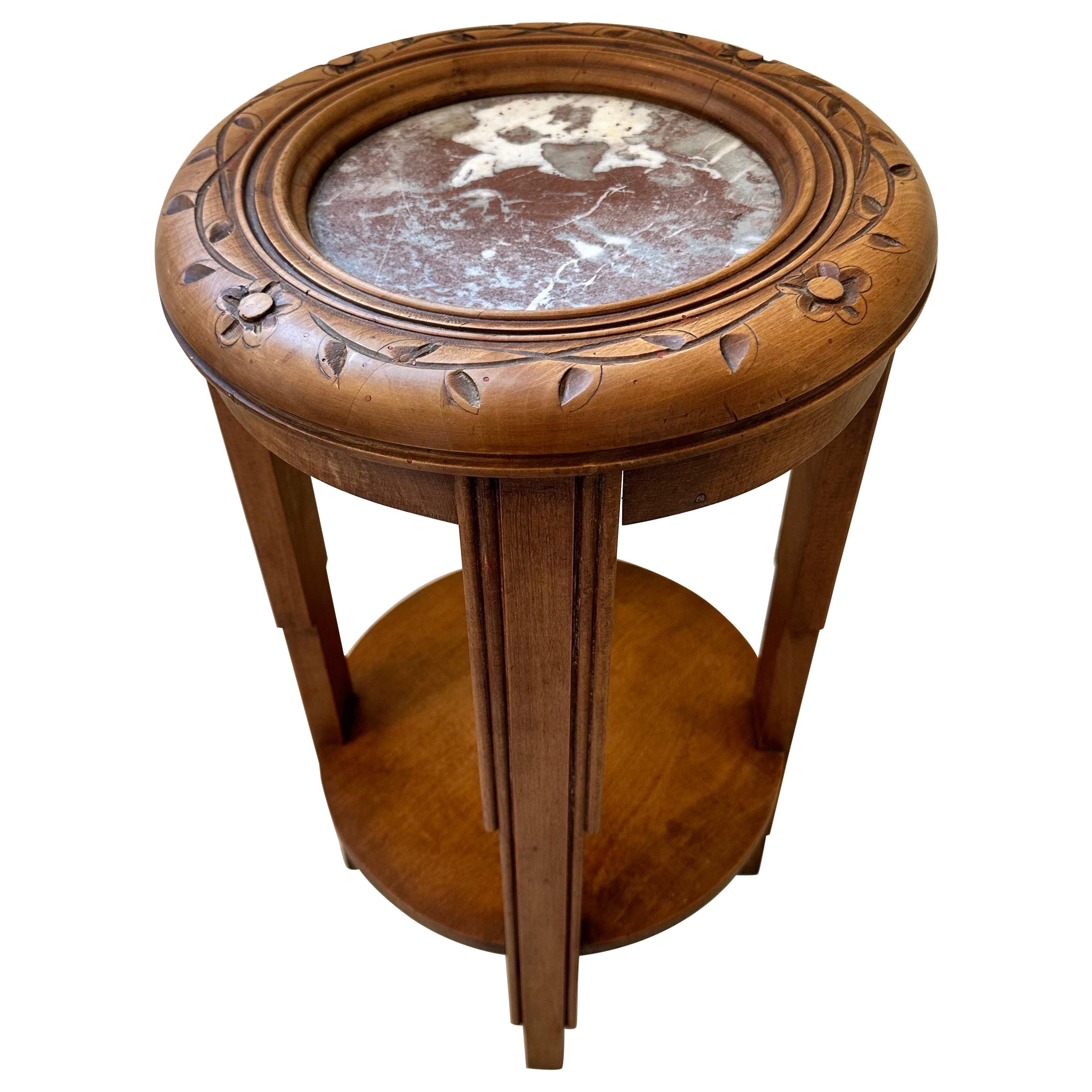 Table ronde unique de style Art Déco moderniste avec un plateau en marbre blanc et rouge profond, entouré de fleurs, de feuilles et de vignes sculptées à la main. Probablement conçu comme un support de plantes. Fabriqué en France mais avec