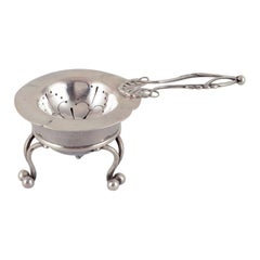 Antique Georg Jensen, early tea strainer with holder in 830 silver.