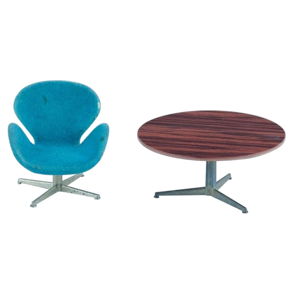 Miniatures of the "Swan" chair and Circular table designed by Arne Jacobsen.
