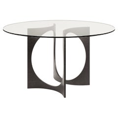 Tavolo da pranzo rotondo Fuga in ghisa e piano in vetro di Metamorphic Studio A