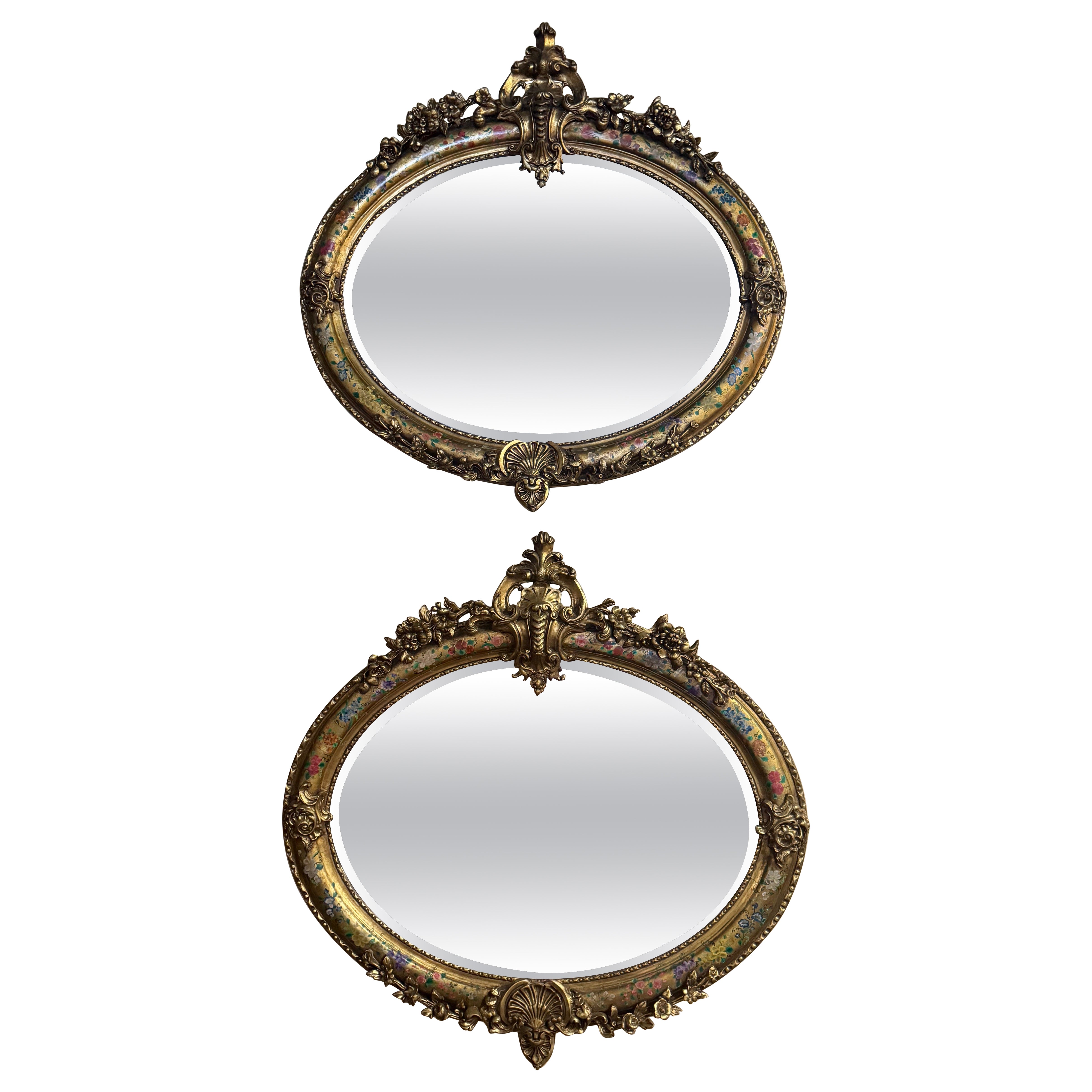 Paar französische Louis XV Spiegel aus geschnitztem Giltholz und mit Malerei verziertes, abgeschrägtes Oval