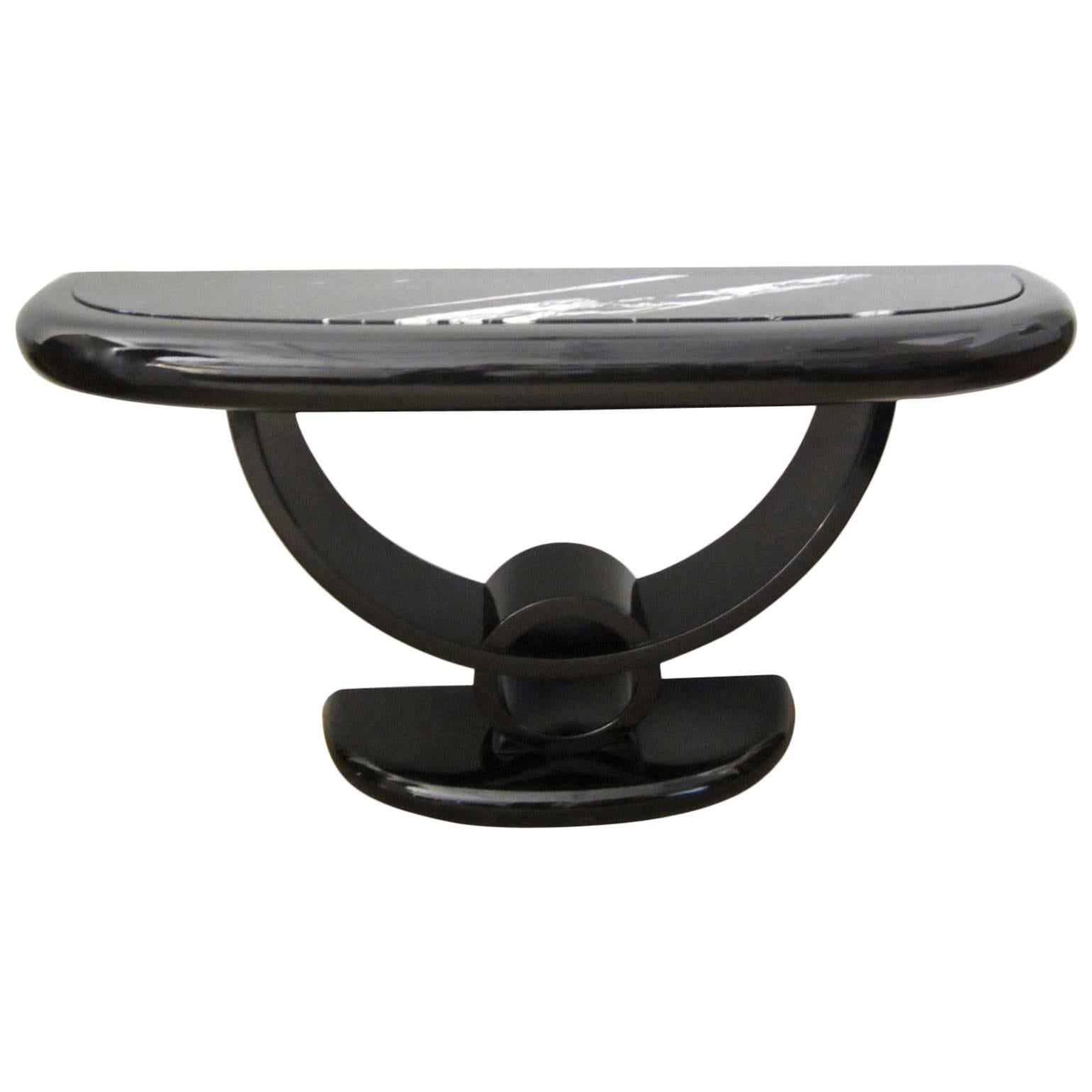 Sculptural black lacquered console table with elegant black and white marble inset top. Some nicks on sides and minor scuffs on bottom but table shines and looks great.
