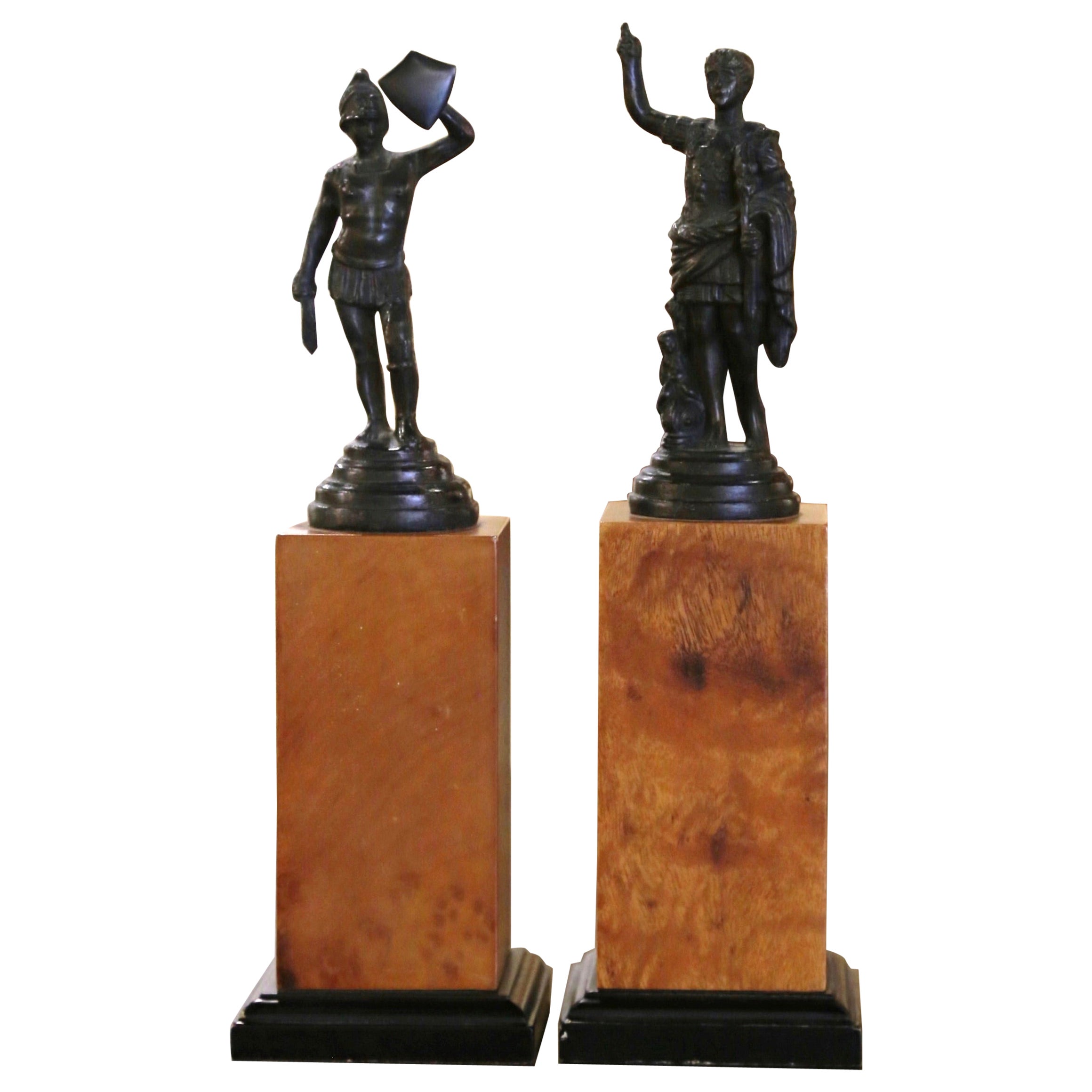 Pareja de estatuas de bronce de finales del siglo XX sobre columnas de madera