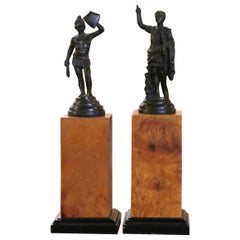 Pareja de estatuas de bronce de finales del siglo XX sobre columnas de madera