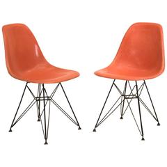 Orangefarbene Eames-Schalenstühle auf Original-Eiffel-Fußgestellen