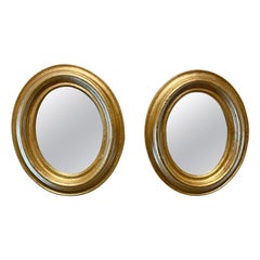 Paire de miroirs italiens ovales dorés anciens