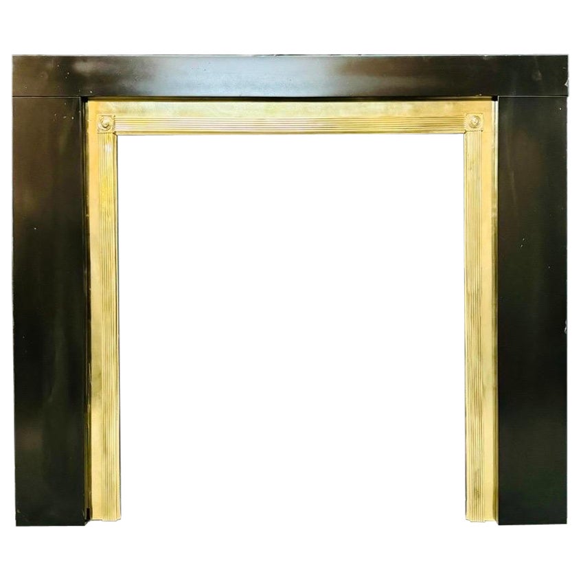 Una cornice per caminetto in ottone lucido in stile Regency.
