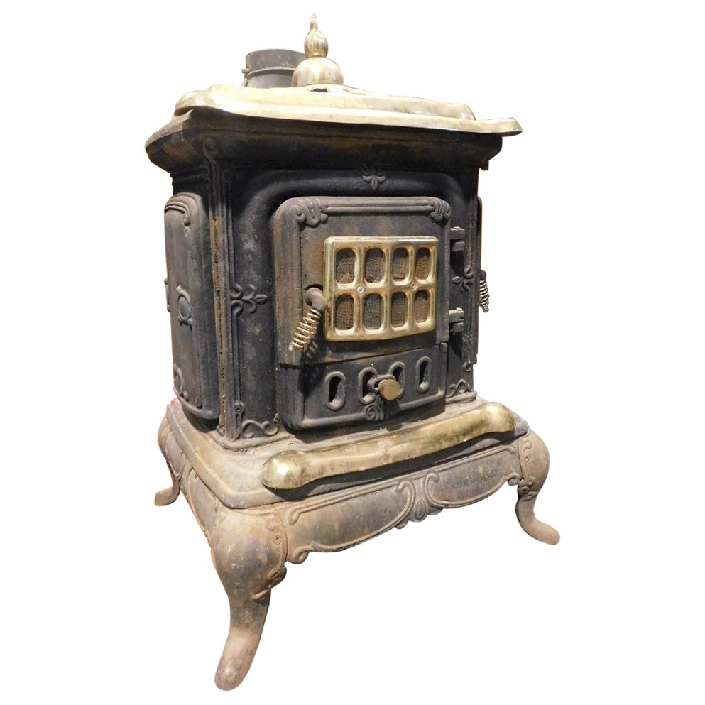 Estufa de leña, marca Parlor Stove, en hierro fundido negro, acabados en latón dorado