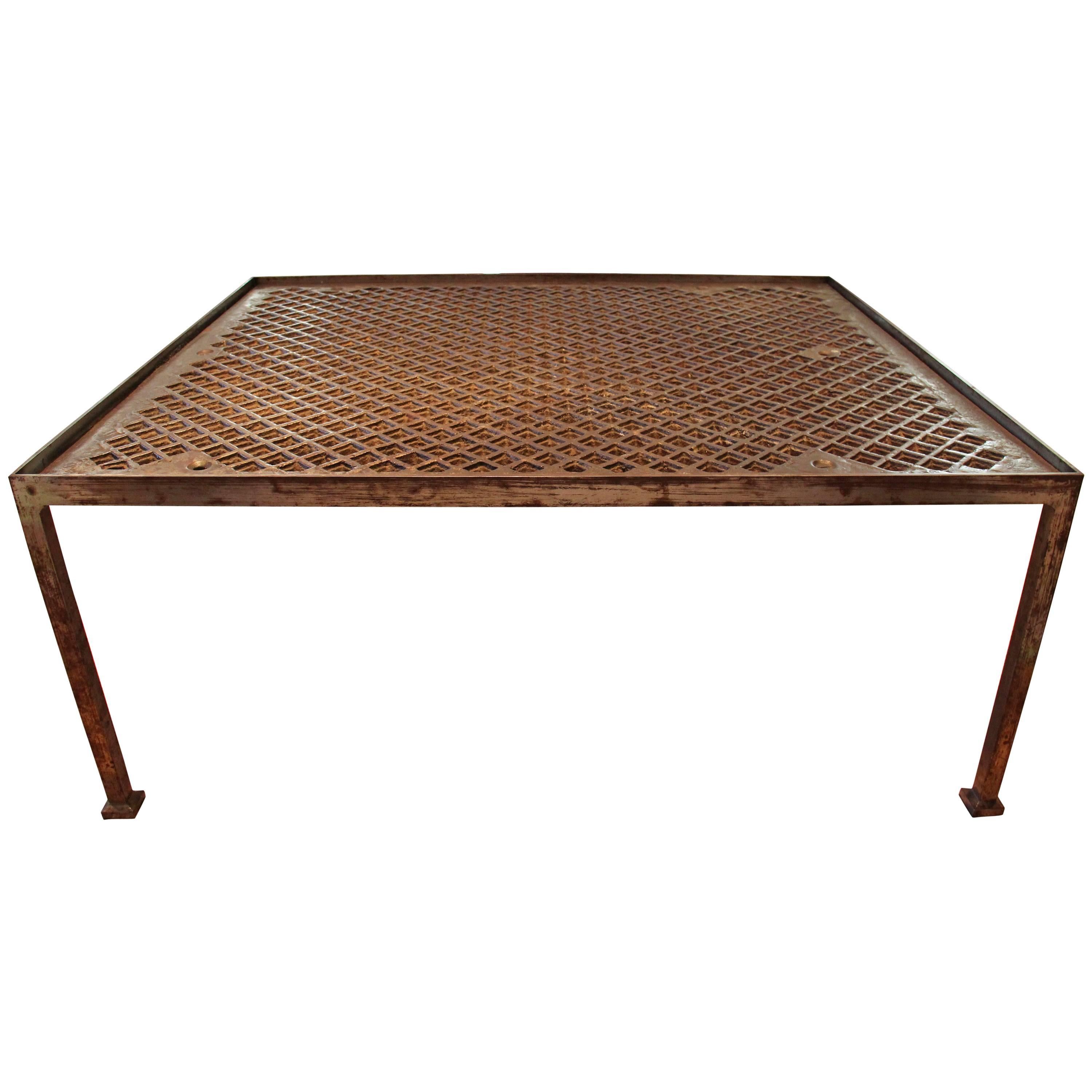 A circa 1960 iron Mid-Century Modern coffee table that came from the estate of an artist in upstate New York.  The iron industrial grate top is circa 1940.  This table would be perfect indoors or outdoors as a coffee table for the patio or loggia.  