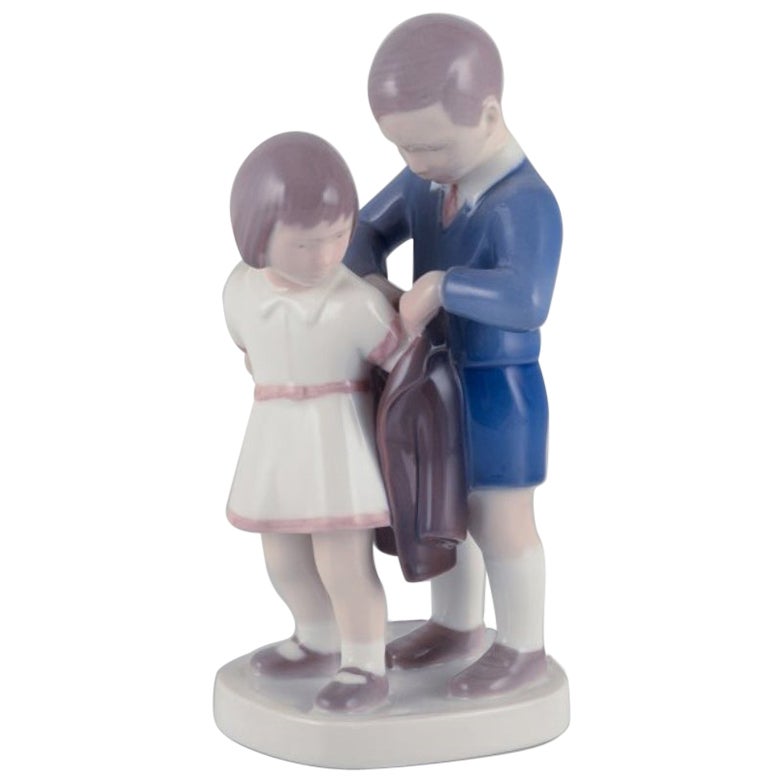 Bing e Grondahl, statuetta in porcellana. Ragazzo che aiuta la ragazza con la sua giacca.