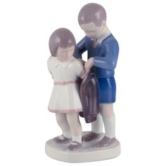 Bing and Grondahl, porcelain figurine. Boy helping girl with her jacket.