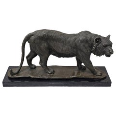 Bronzeskulptur eines pirschenden Tigers mit brauner Patina auf einem Sockel aus gesprenkeltem Marmor