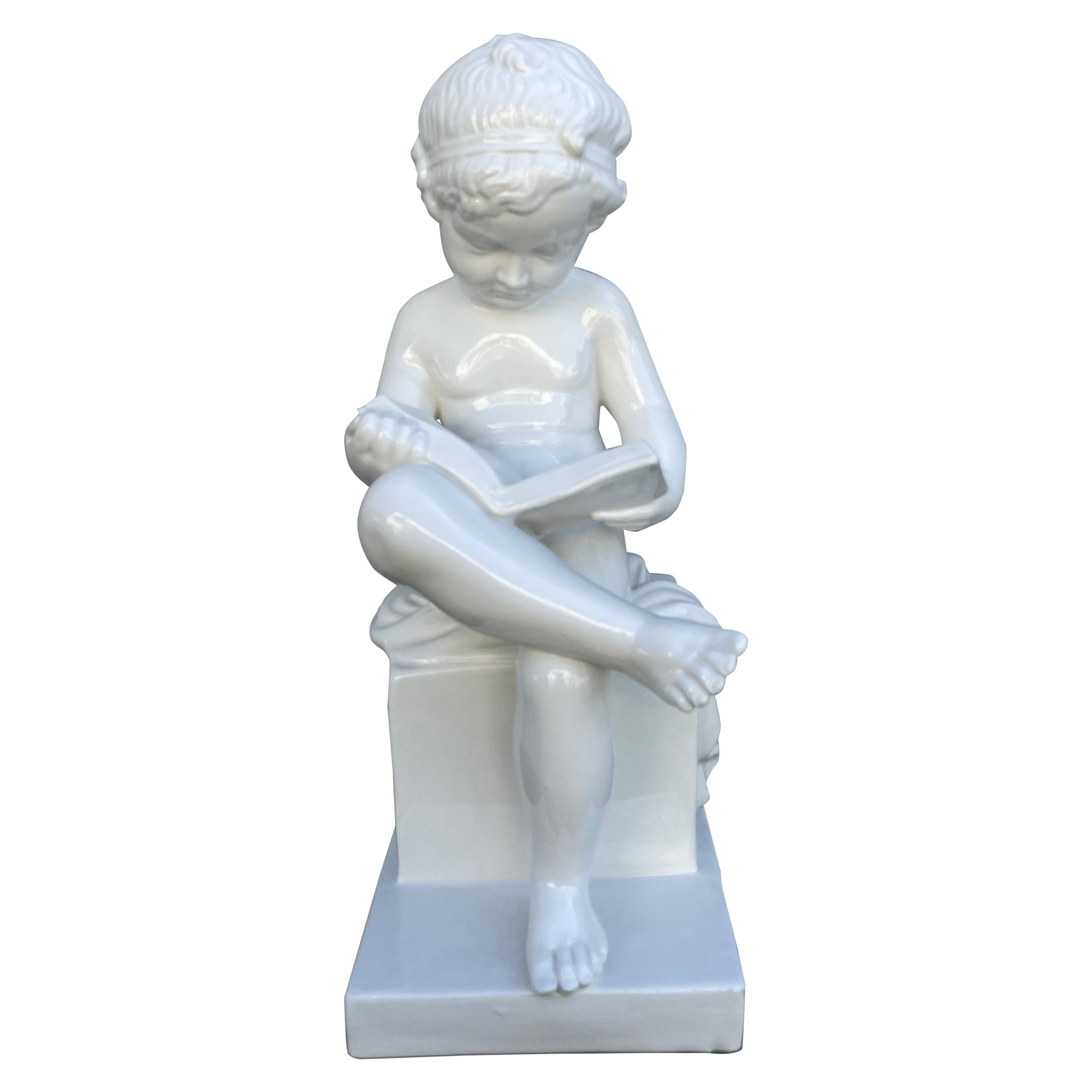 Putto seduto in porcellana bianca italiana che legge un libro