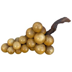 Racimo monumental de uvas amarillas italianas de piedra sobre rama de madera