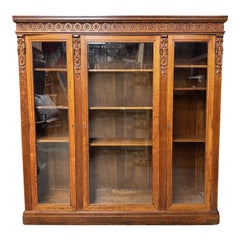 Librería antigua de tres puertas con frente de cristal de roble tallado