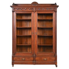 Bibliothèque victorienne ancienne en noyer sculpté de style Herter Brothers