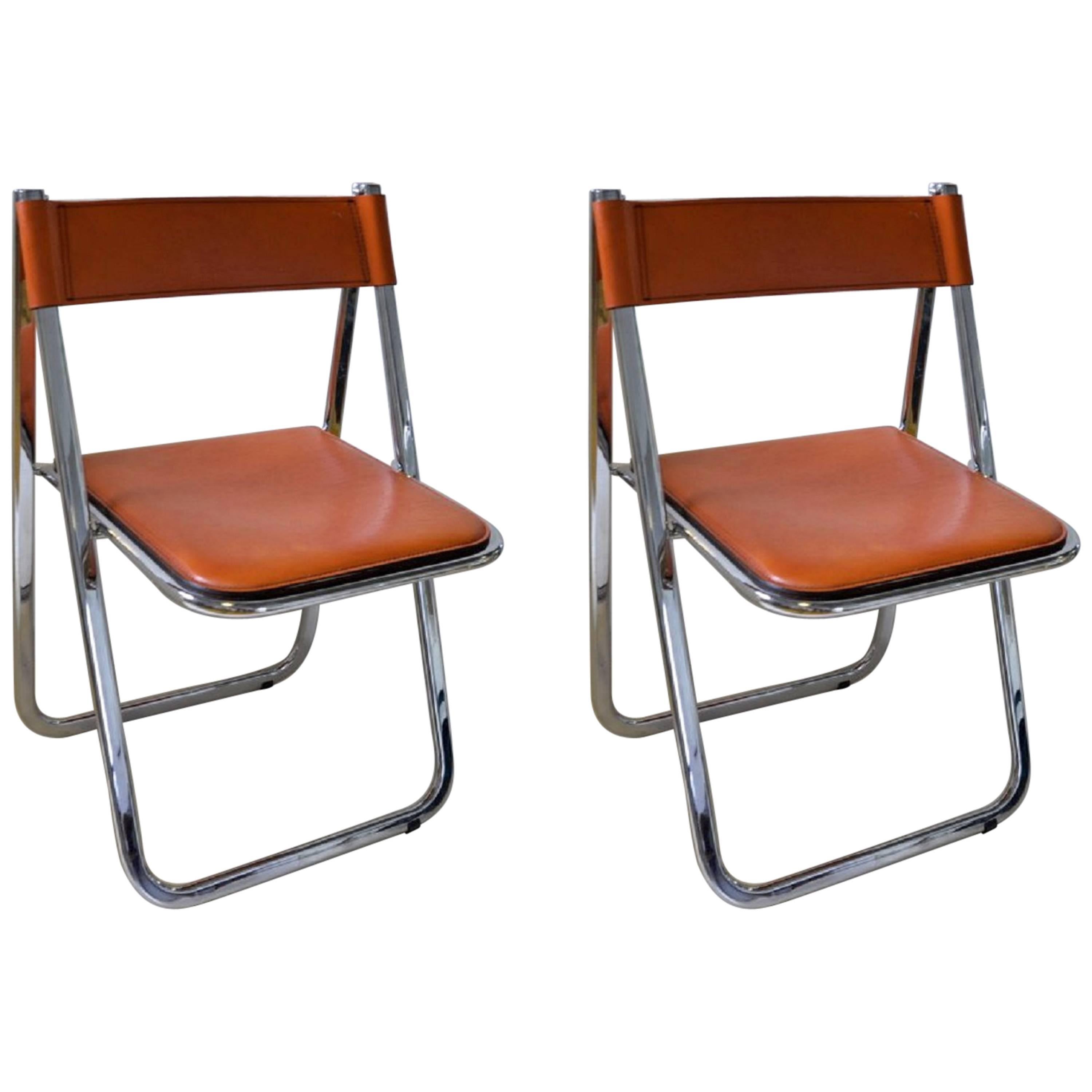 This pair of Tamara folding chairs by Italian maker Arrben is the quintessential example of the form in split leather and chrome-plated steel polished to a mirror finish. The original floor protectors are present.

We also have a set of four of