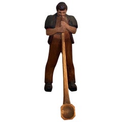 Black Forest wood carving of man blowing a swiss horn