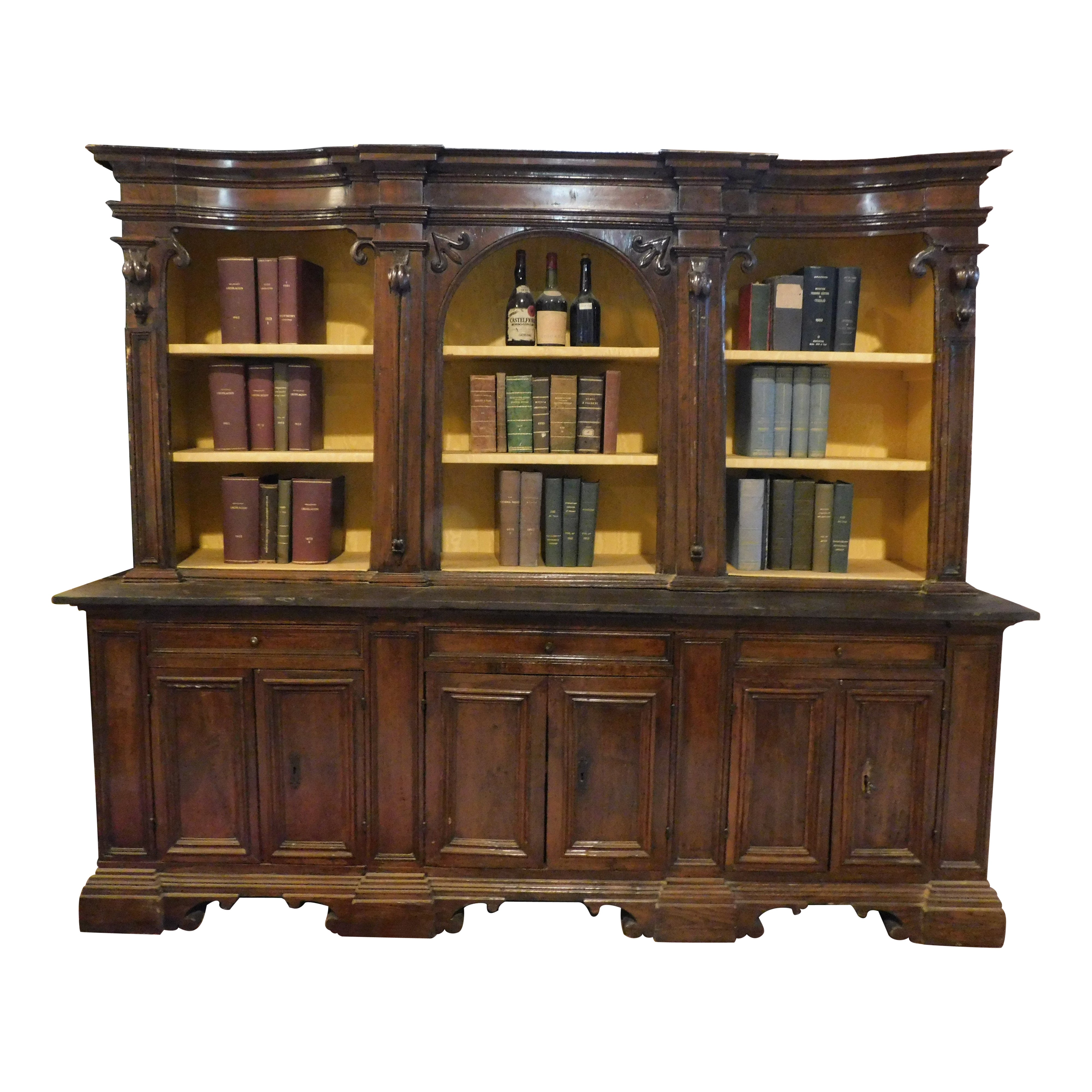 Walnut bookcase with carved columns, doors and open shelves, Italy