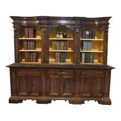 Walnut bookcase with carved columns, doors and open shelves, Italy