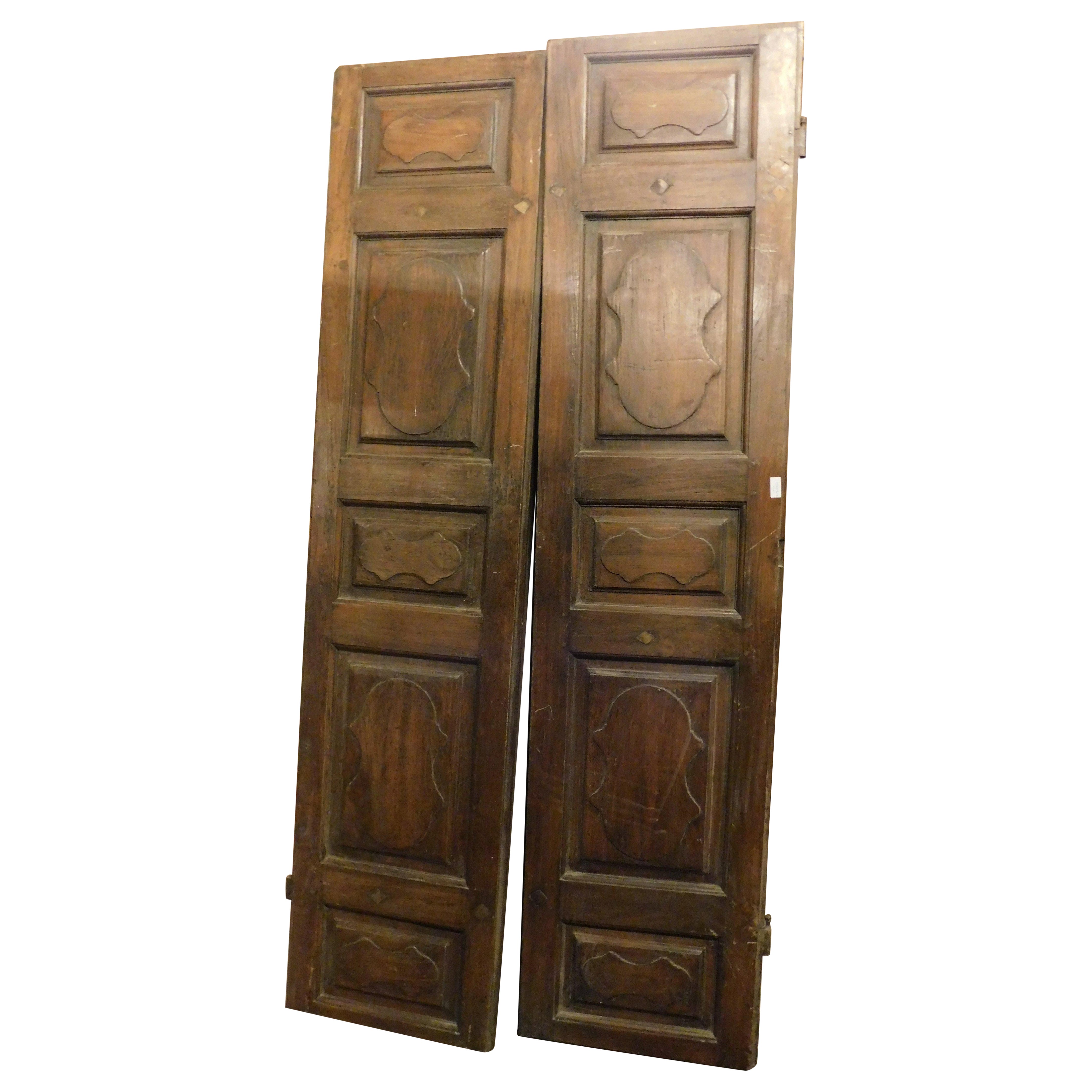 Puerta interior de madera de nogal, dos hojas con paneles tallados, Italia