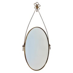 Espejo de pared con borla de pajarita ovalada de latón estilo Hollywood Regency Italia años 70