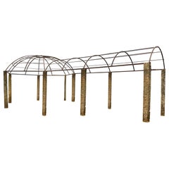 Pérgola de hierro forjado con pilares de monolito de granito