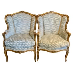 Pareja de sillas bergere antiguas de madera dorada de estilo Luis XV francés