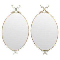 A pair of Italian 1940s oval mirrors with dolphin detailing around the frame