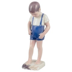Bing & Grøndahl, Dinamarca. Figurita de porcelana de un niño y un cangrejo.