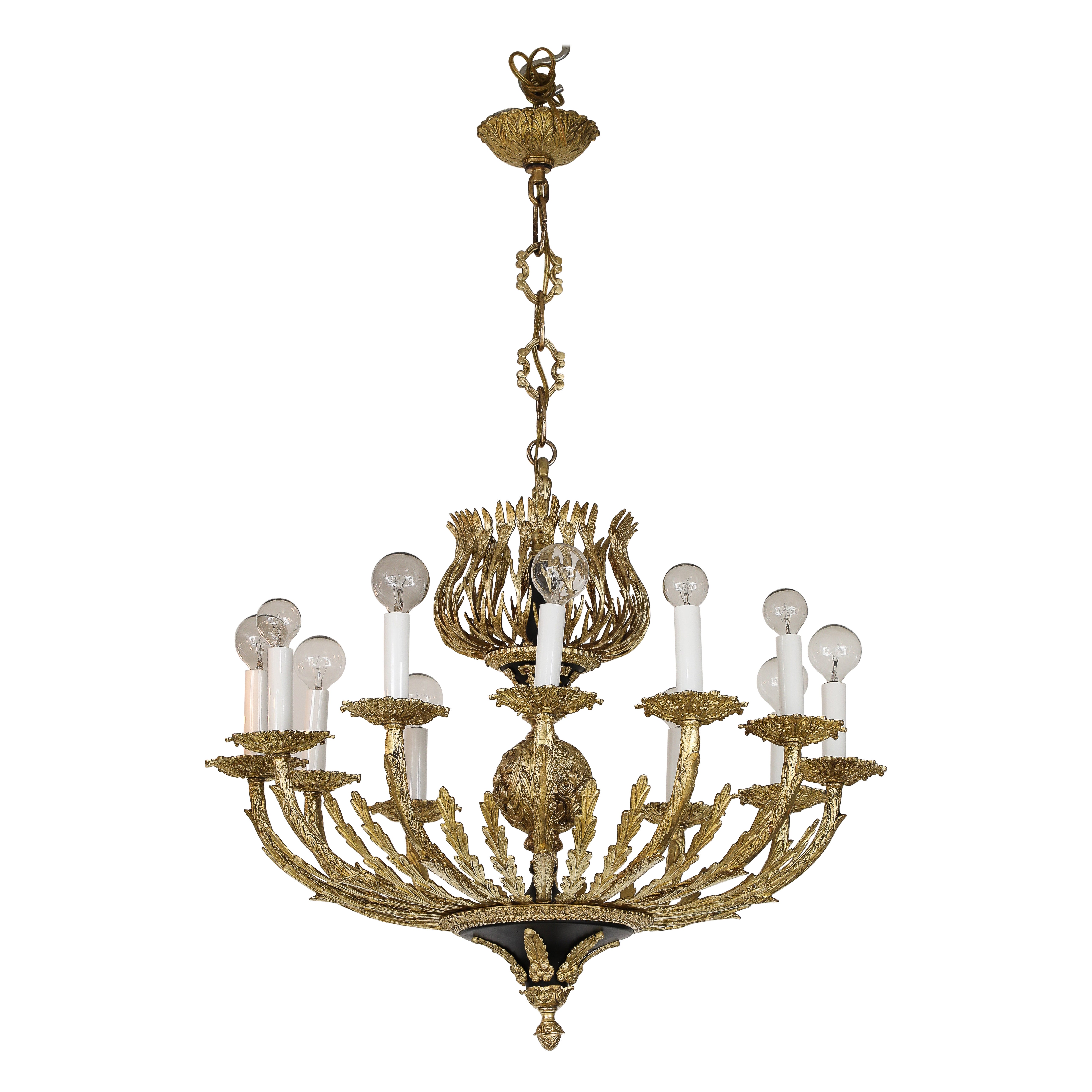 Lampadario a 12 bracci in ottone francese degli anni '50 con splendidi dettagli artigianali, completamente restaurato, lucidato e ricablato con lievi segni di usura e patina dovuti all'età e all'uso.