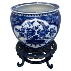 Olla china vintage azul y blanca sobre soporte