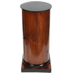 A Walnut and Ebonized Wood Biedermeier Cylindrical Pedestal Cupboard