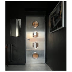 Contemporary custom made Spinzi stainless steel metal door with round portholes