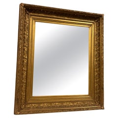 Gilded wood wall mirror, richly carved with leaf decorations, Italy