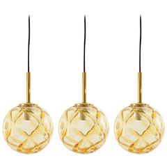 Three Doria Pendant Lights, Brass and Textured Amber Glass Globe, 1960s