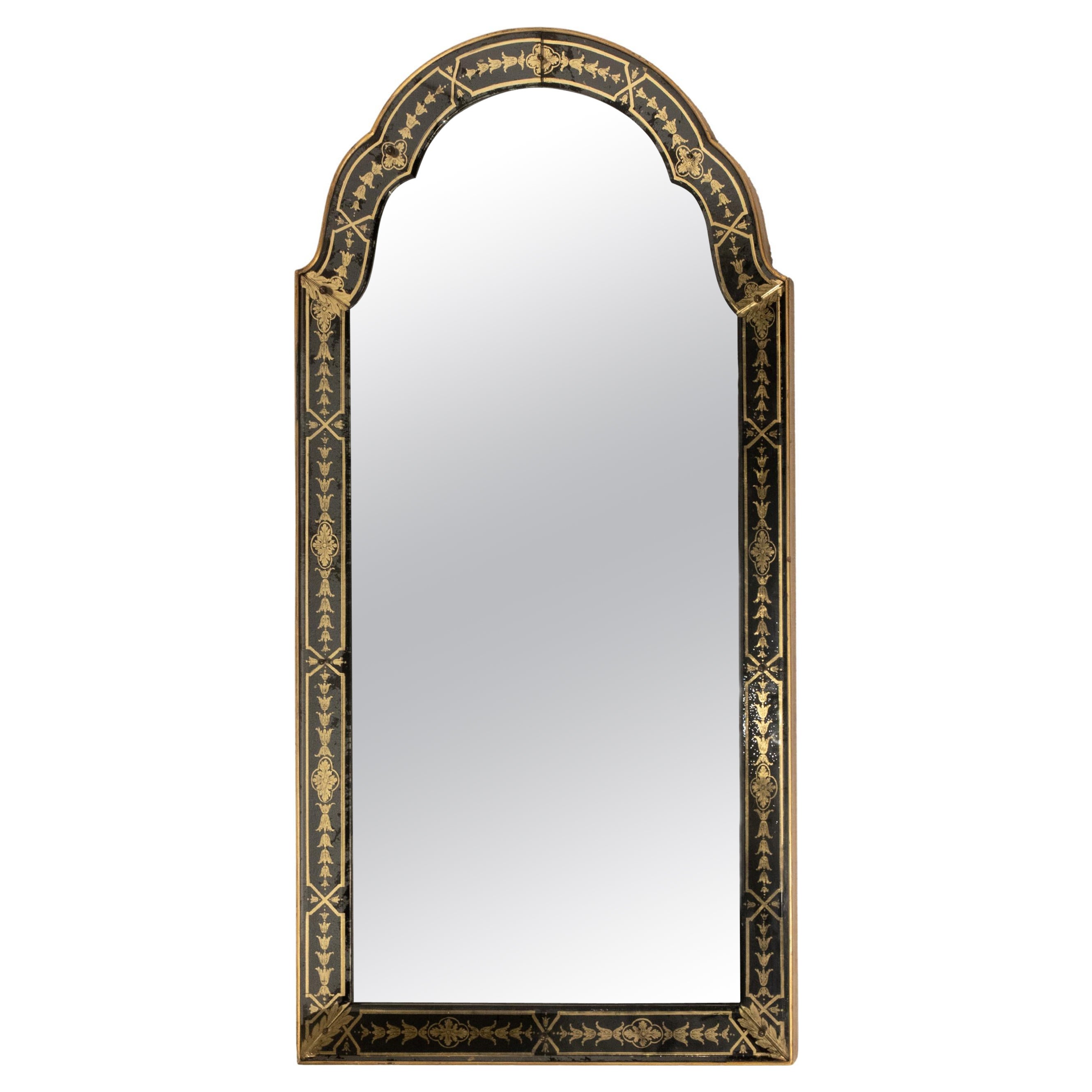 Un miroir arqué avec cadre décoré en verre inversé