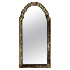 Un miroir arqué avec cadre décoré en verre inversé