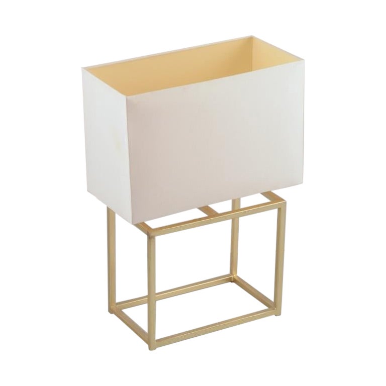 Lampe de table Designer en laiton avec un abat-jour en tissu blanc.