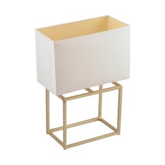 Designer table lamp in brass with a white fabric shade.