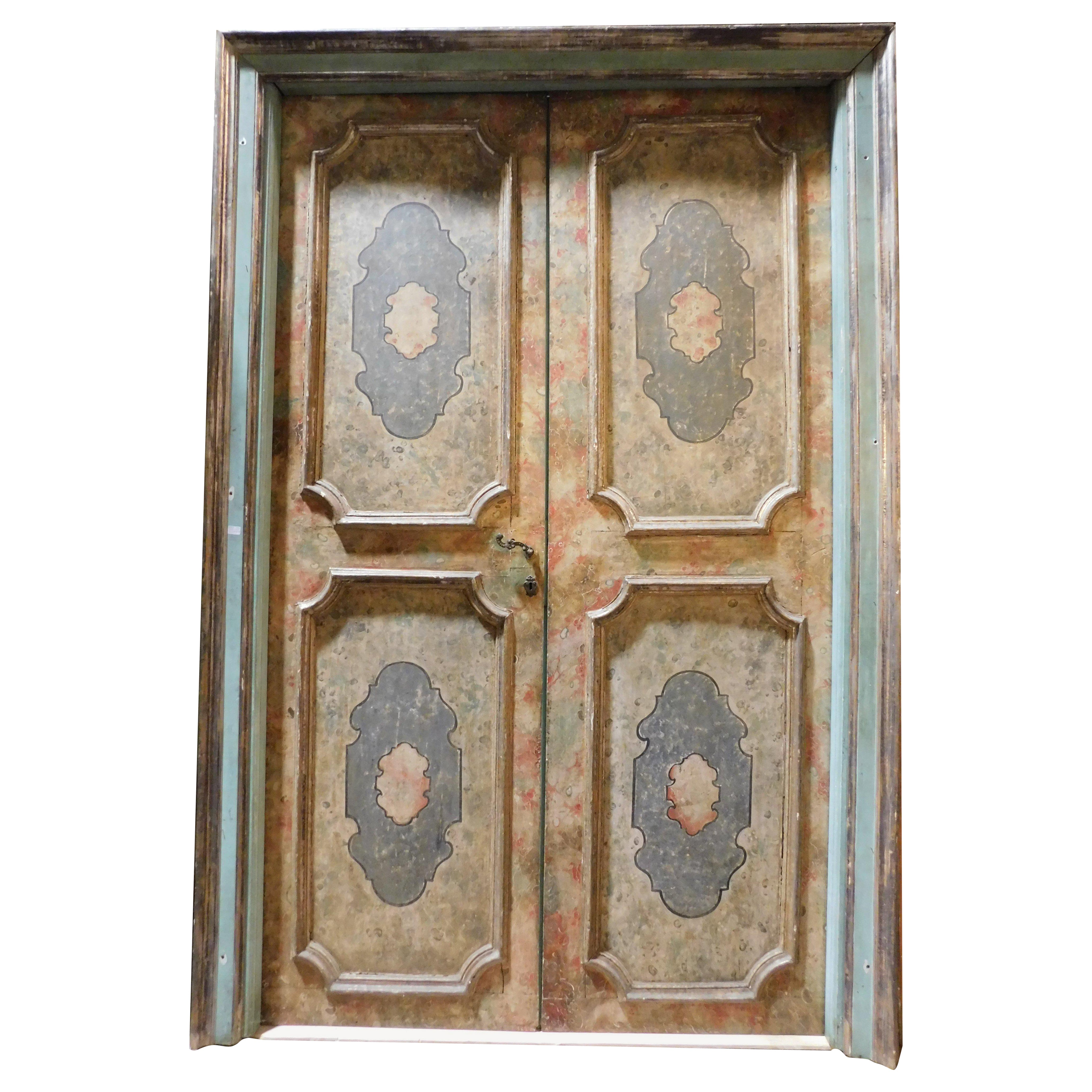 Puerta interior antigua de doble hoja, de madera maciza lacada y ricamente pintada con decoraciones de falso mármol y barrocas, completa con marco original y de doble cara: parte trasera lacada y pintada como la delantera. Tiene una abertura de
