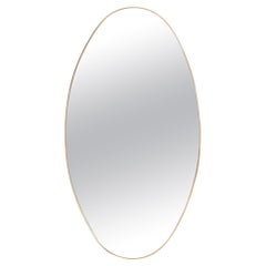 Oval-shaped mirror set with a gilded brass. 1970s.