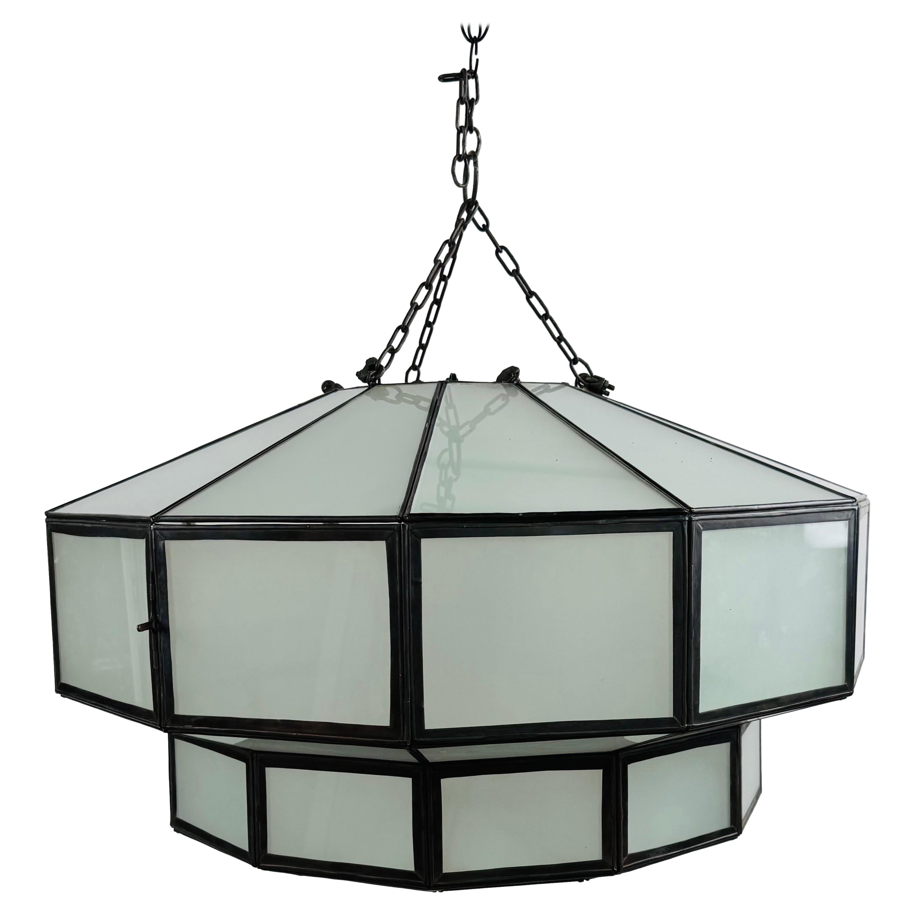 Lampadario o ciondolo circolare in vetro bianco e bronzo in stile Art Deco: 
Questa sorprendente lampada a sospensione in stile Art Déco è una miscela magistrale di precisione geometrica e materiali raffinati, che evoca la grandezza del design del