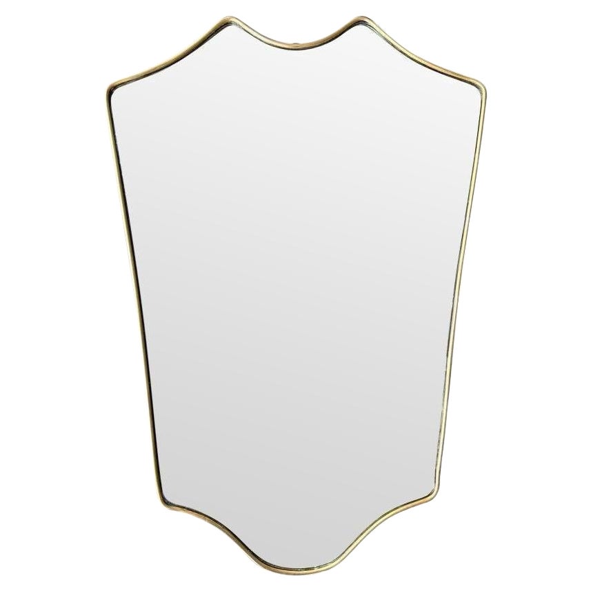 Miroir en laiton original des années 1950, avec une belle forme incurvée.