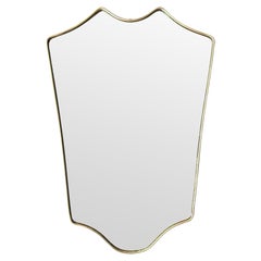 An orignal Italian 1950s brass framed shield mirror with lovely curved shape.
