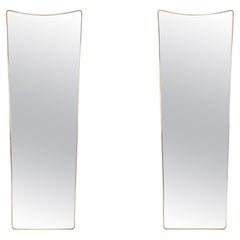 Pair of narrow gilded brass mirrors. Circa 1970.