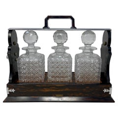 Antiguo Tántalo Inglés de Plata, Madera de Coromandel y Cristal Tallado de 3 Botellas.